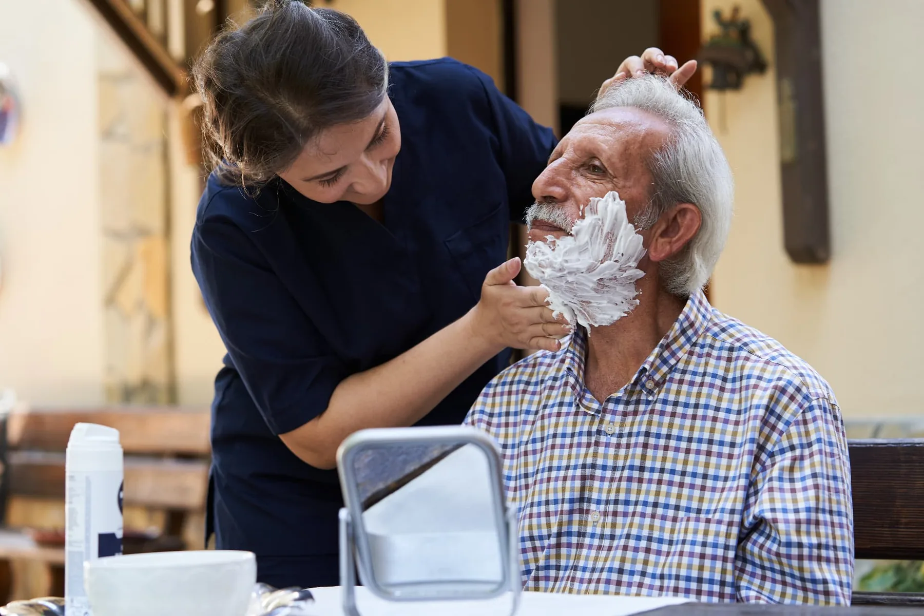 Caregiver helping an older man shave